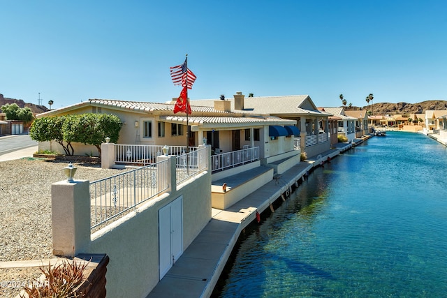 view of front facade with a water view and a pool