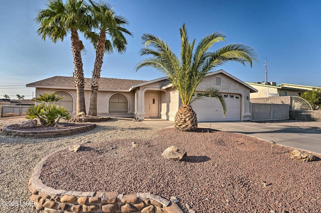 single story home featuring driveway, an attached garage, fence, and stucco siding