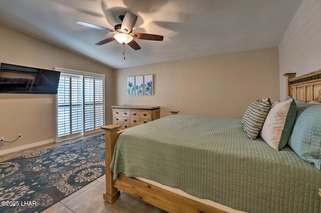 tiled bedroom featuring lofted ceiling and a ceiling fan