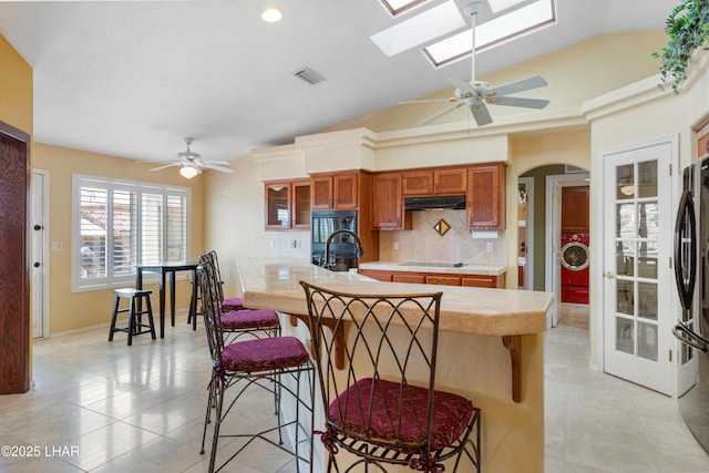 1901 Gold Dust Dr, Lake Havasu City, AZ 86404 - kitchen featuring under cabinet range hood, washer / dryer, a breakfast bar, ceiling fan, and lofted ceiling