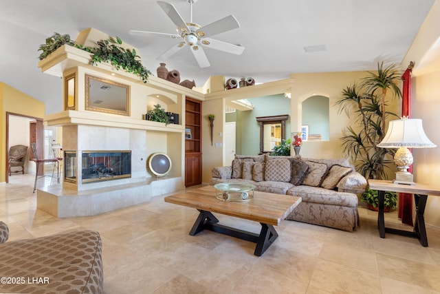 1901 Gold Dust Dr, Lake Havasu City, AZ 86404 - living room featuring built in features, ceiling fan, a tiled fireplace, vaulted ceiling, and light tile patterned floors