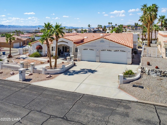 1901 Gold Dust Dr, Lake Havasu City, AZ 86404 - mediterranean / spanish-style house with a gate, concrete driveway, an attached garage, a tile roof, and stucco siding