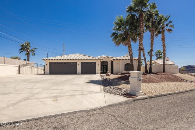2008 Martinique Dr, Lake Havasu City, AZ 86406 - mediterranean / spanish home with stucco siding, an attached garage, a tile roof, driveway, and a gate