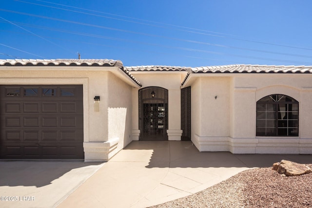 2008 Martinique Dr, Lake Havasu City, AZ 86406 - view of exterior entry with a garage, stucco siding, and a tiled roof