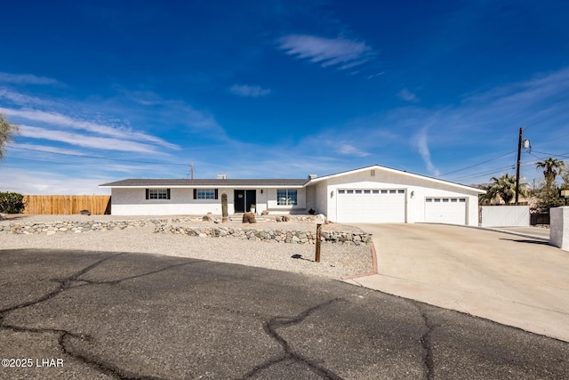 single story home with driveway, an attached garage, fence, and stucco siding