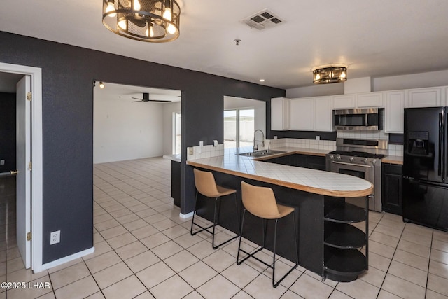 2230 Havasupai Blvd, Lake Havasu City, AZ 86403 - kitchen with stainless steel appliances, a sink, white cabinetry, and a peninsula