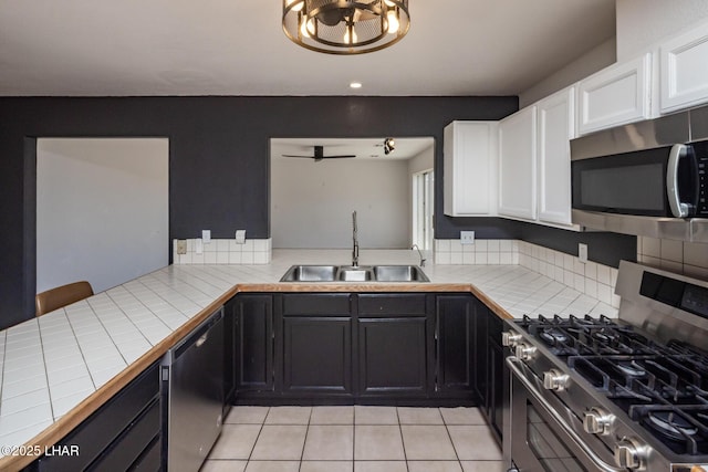 2230 Havasupai Blvd, Lake Havasu City, AZ 86403 - kitchen with appliances with stainless steel finishes, tile countertops, a sink, white cabinets, and light tile patterned floors