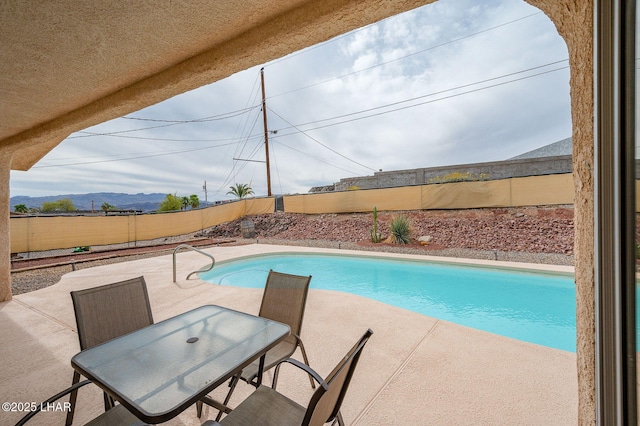 view of pool featuring a fenced in pool, a fenced backyard, a patio, and a mountain view