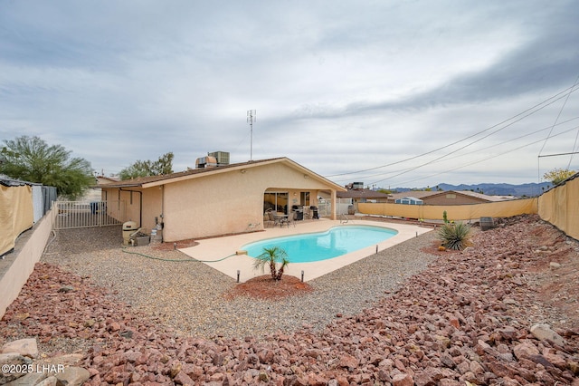 view of pool with a patio area, a fenced backyard, central AC, and a fenced in pool