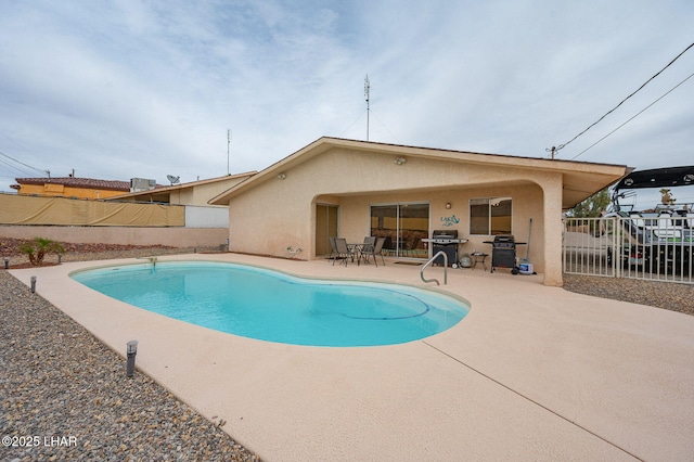 view of pool with a patio, area for grilling, and fence