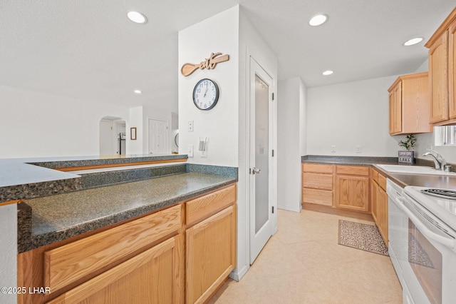 kitchen with white electric stove, dark countertops, a sink, and recessed lighting