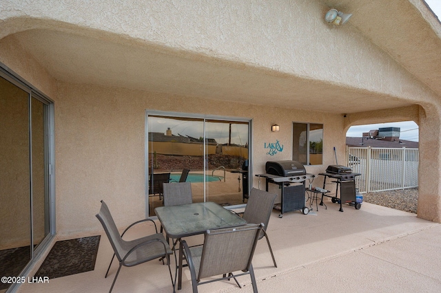 view of patio featuring outdoor dining area, fence, and grilling area