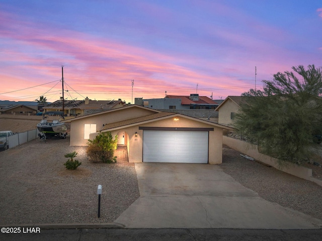 single story home with driveway, an attached garage, fence, and stucco siding