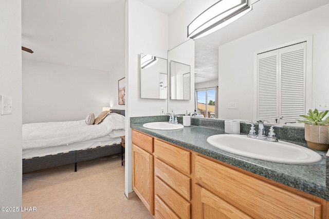 bathroom featuring tile patterned floors, a sink, ensuite bath, and double vanity