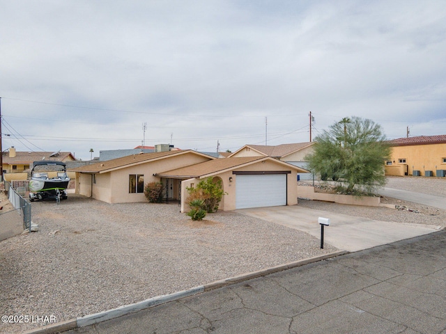 ranch-style home with a garage, stucco siding, driveway, and fence