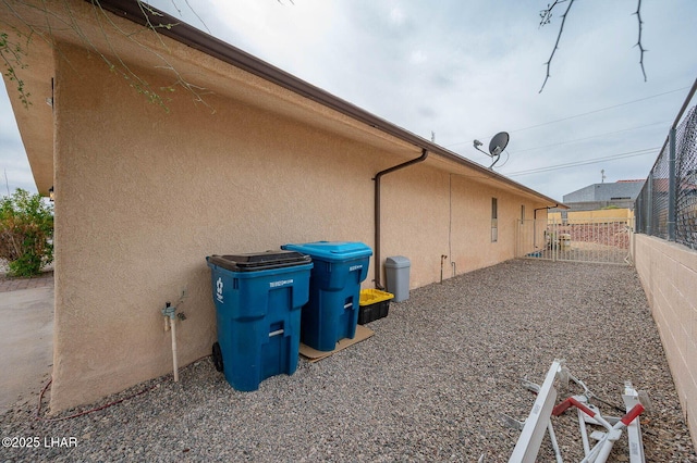 view of home's exterior featuring a gate, fence, and stucco siding