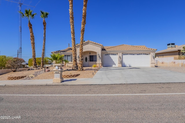 mediterranean / spanish-style house featuring a garage, concrete driveway, a tile roof, and stucco siding