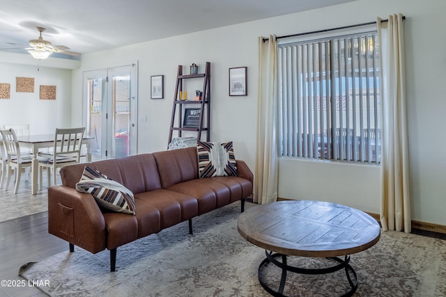 living room with baseboards, wood finished floors, a wealth of natural light, and a ceiling fan