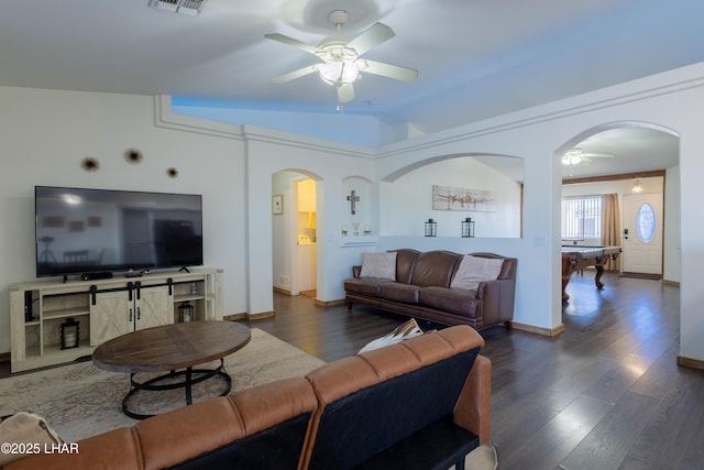 living room featuring visible vents, arched walkways, dark wood finished floors, a ceiling fan, and vaulted ceiling