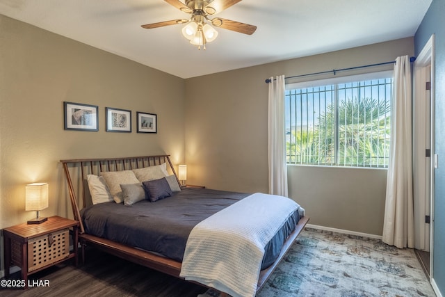 bedroom featuring ceiling fan, baseboards, and wood finished floors