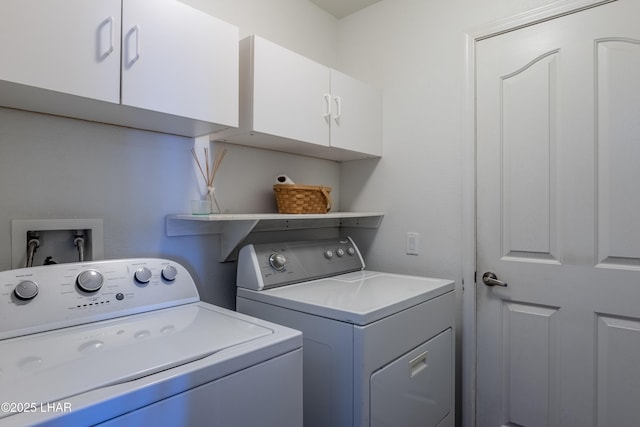 clothes washing area featuring cabinet space and washer and clothes dryer