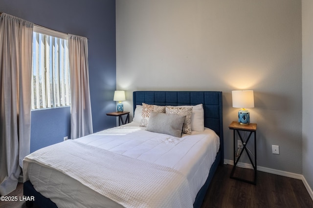 bedroom with dark wood-style floors and baseboards