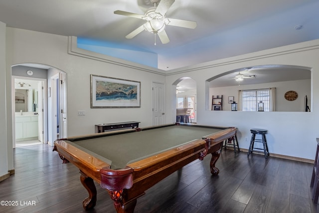 playroom with arched walkways, dark wood-style floors, and a ceiling fan