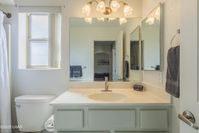 full bathroom featuring ensuite bathroom, vanity, toilet, and an inviting chandelier