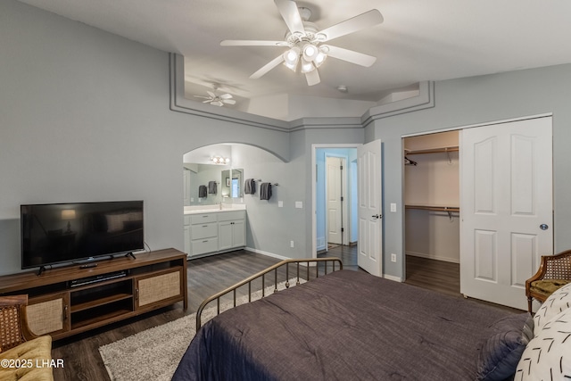 bedroom with arched walkways, dark wood-style flooring, a closet, and a ceiling fan