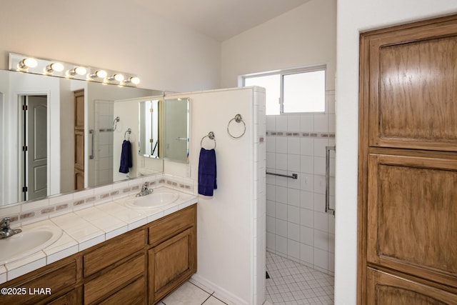 full bath with double vanity, a stall shower, tile patterned flooring, and a sink