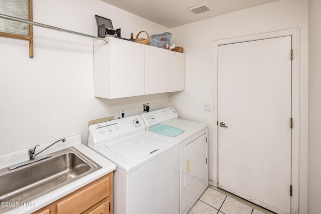 laundry room featuring light tile patterned floors, visible vents, cabinet space, washing machine and dryer, and a sink