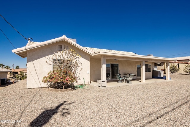 rear view of house featuring a patio area and stucco siding