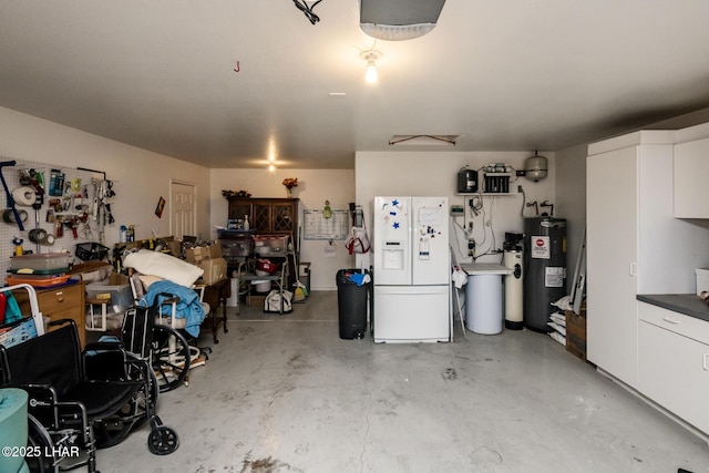 garage with white refrigerator with ice dispenser and electric water heater