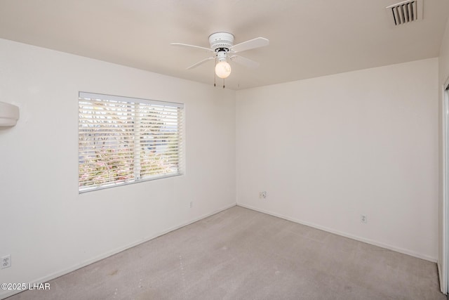 unfurnished room with baseboards, carpet floors, visible vents, and a ceiling fan