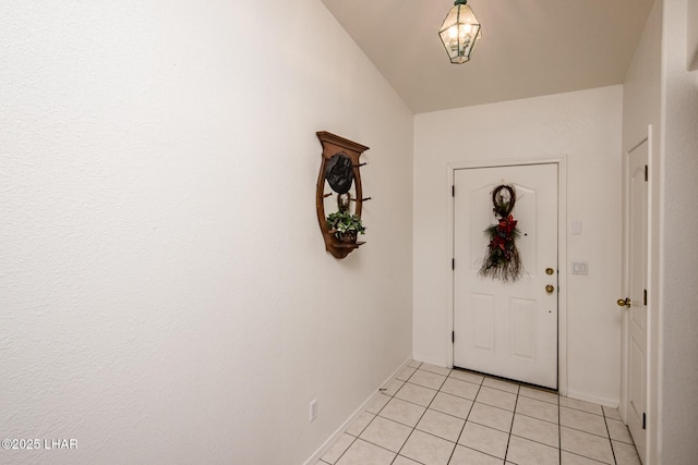 doorway to outside featuring baseboards and light tile patterned floors