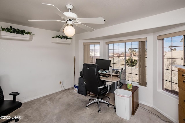 office area featuring baseboards, a ceiling fan, and light colored carpet