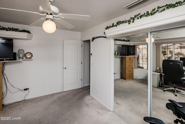 carpeted office space with a ceiling fan, visible vents, and baseboards