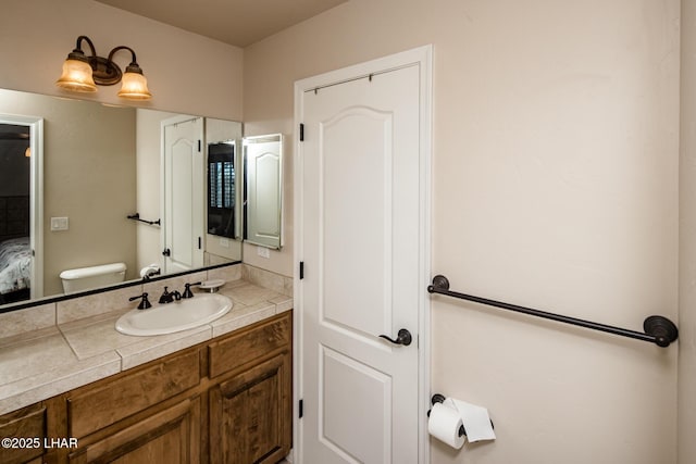 bathroom featuring connected bathroom, vanity, and toilet