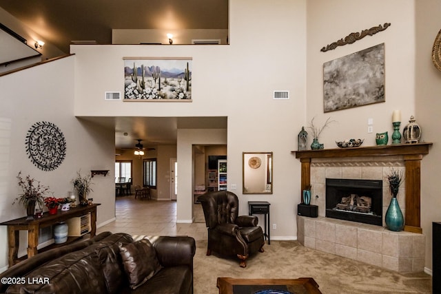 living area featuring a high ceiling, a ceiling fan, and visible vents