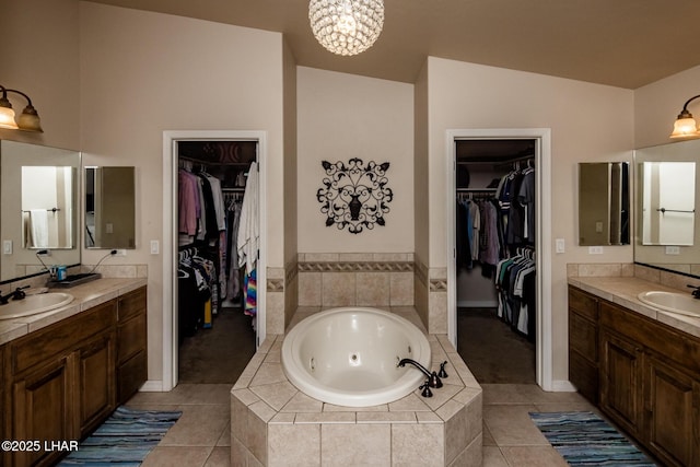 bathroom with a sink, a tub with jets, and tile patterned flooring