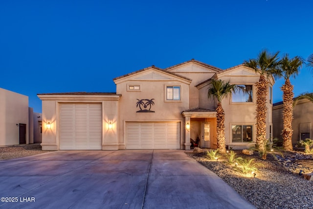 mediterranean / spanish home featuring concrete driveway and stucco siding