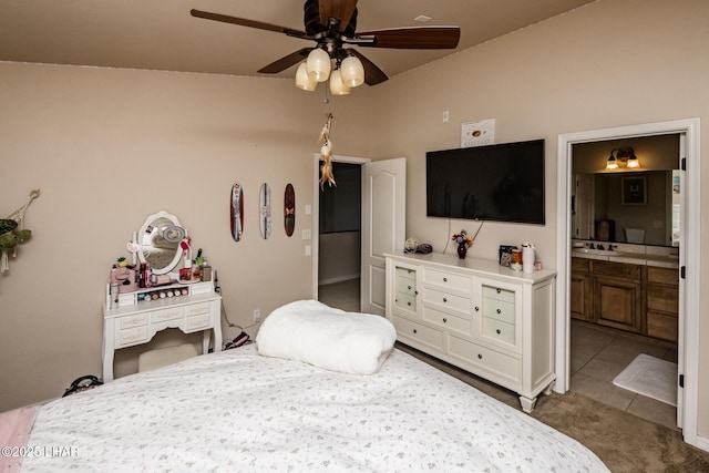 bedroom featuring tile patterned floors, connected bathroom, carpet, and a ceiling fan