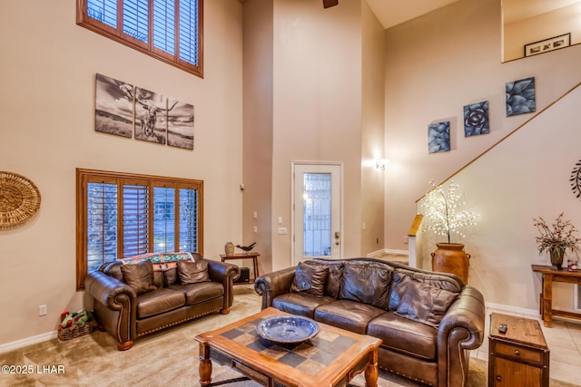 carpeted living area with baseboards and a high ceiling