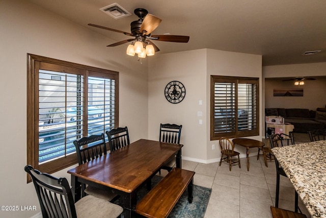 dining room with light tile patterned flooring, visible vents, baseboards, and ceiling fan