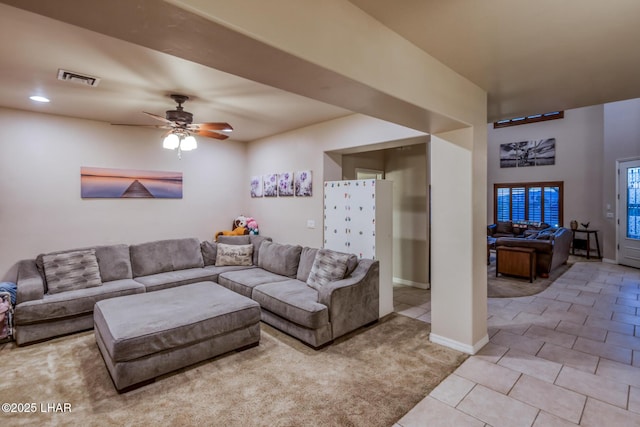 tiled living room with a ceiling fan, visible vents, and baseboards