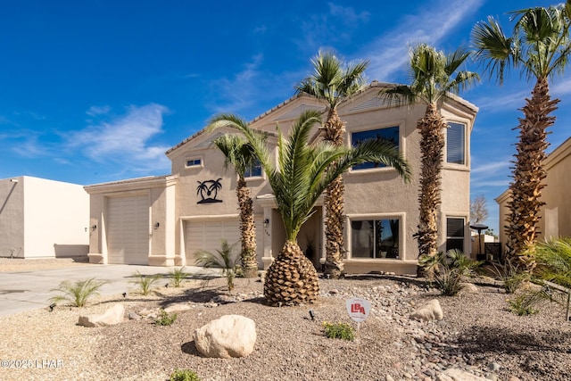 view of front of property with stucco siding, concrete driveway, and an attached garage