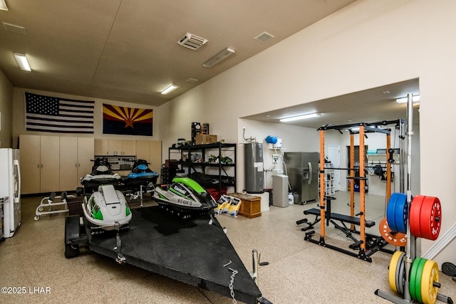 workout room featuring visible vents and electric water heater