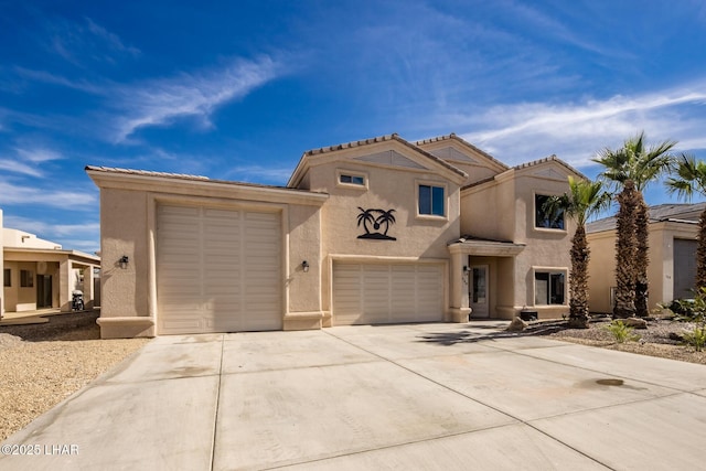 view of front of house with stucco siding, a garage, and driveway