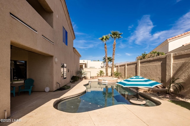 view of swimming pool with a pool with connected hot tub, a fenced backyard, and a patio area