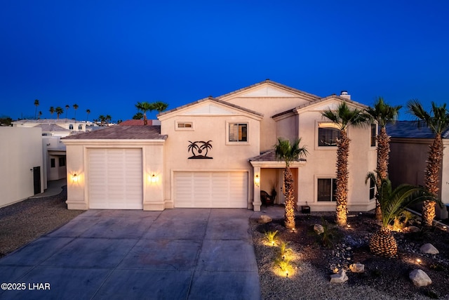 view of front of property with concrete driveway, a garage, and stucco siding